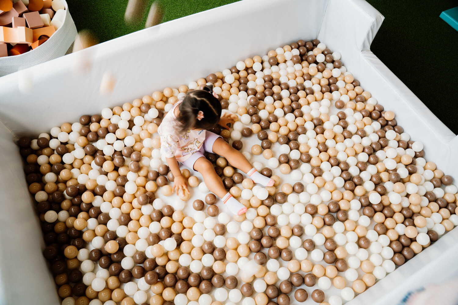 Toddler playing in the neutral-toned ball pit at The Plae House in Ajax